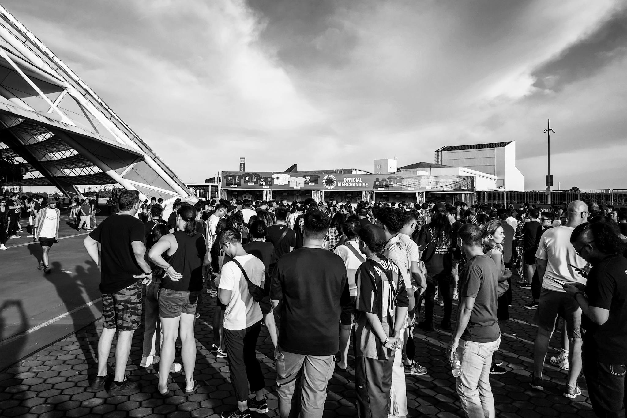 A bustling crowd gathers for a concert in Singapore, showcasing urban life and fan excitement.