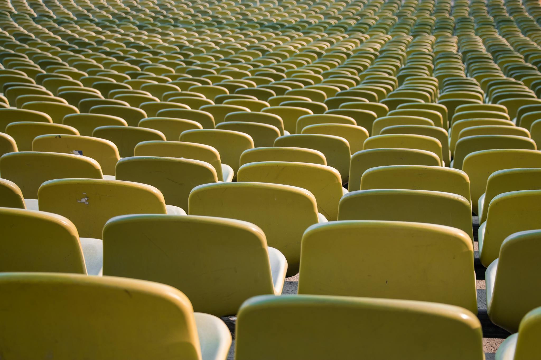 Rows of empty yellow seats in a stadium in Munich, Germany, emphasizing repetition and symmetry.